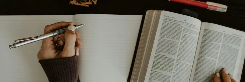 Open Bible and notebook on a table as someone studies Scripture and writes notes